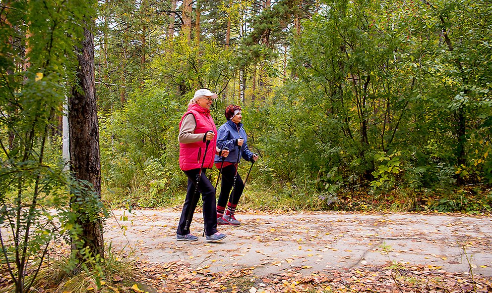 Två äldre damer promenerar med stavar.